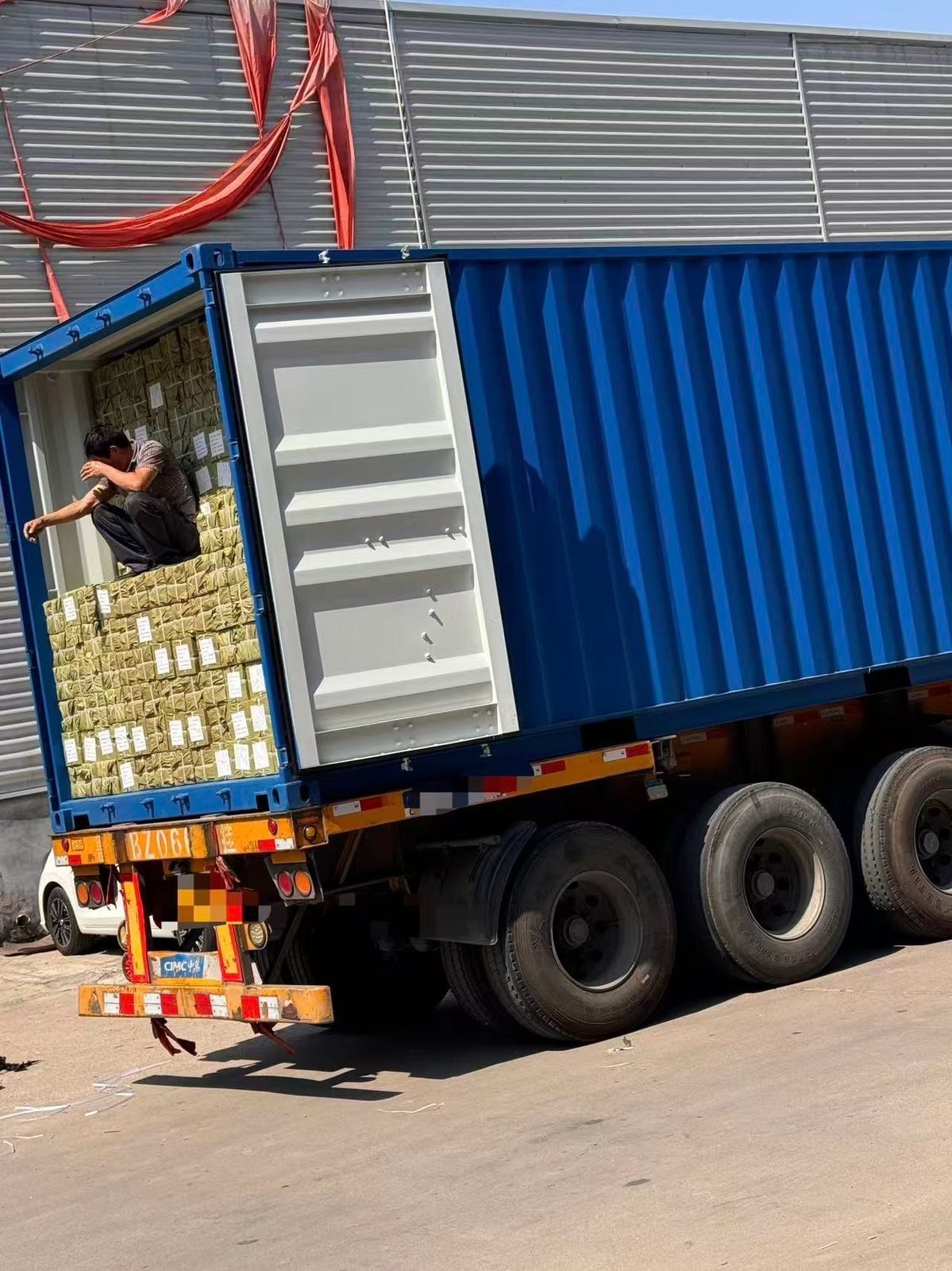 A worker loading cartons inside a shipping container at the Wildleg factory.
